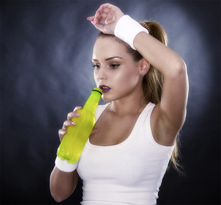Athletic woman drinking an energy drink